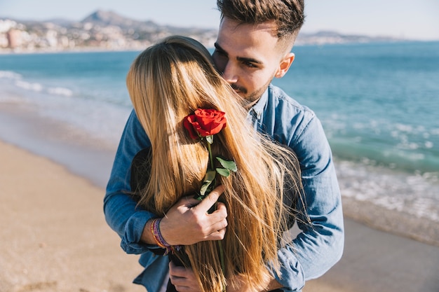 abracando-o-casal-romantico-com-rosa_23-
