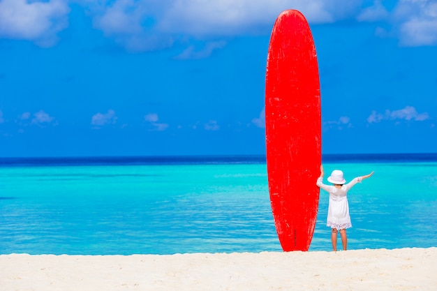 Adorável menina com prancha grande durante férias tropicais Foto Premium