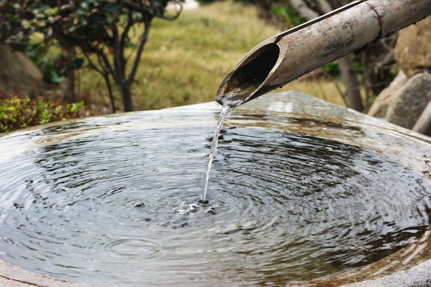 Água de bambu natural japonesa da tubulação que flui no lugar da lavagem. Foto Premium
