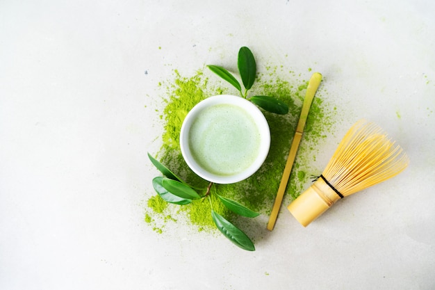 Apartamento leigos de chá verde orgânico matcha em pó com ferramentas japonesas chasen whisk de bambu Foto Premium