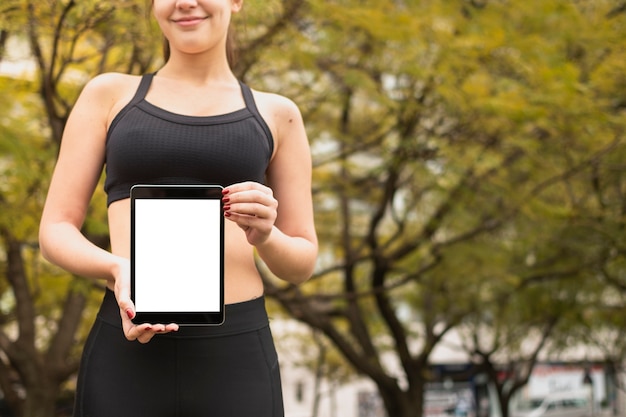 Apta atleta segurando o tablet com maquete Foto gratuita