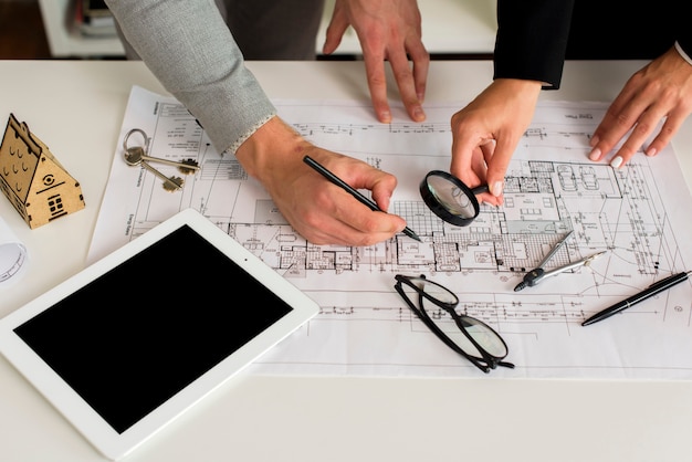 Arquitetos, analisando o plano com lupa Foto gratuita