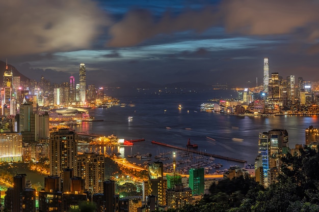 Arranha-céu de hong kong cityscape na hora do crepúsculo, hong kong central e ilha de kowloon, victoria pico e porto, aventura e trekking no ponto de vista do cume vermelho queimador de incenso para viajantes Foto Premium