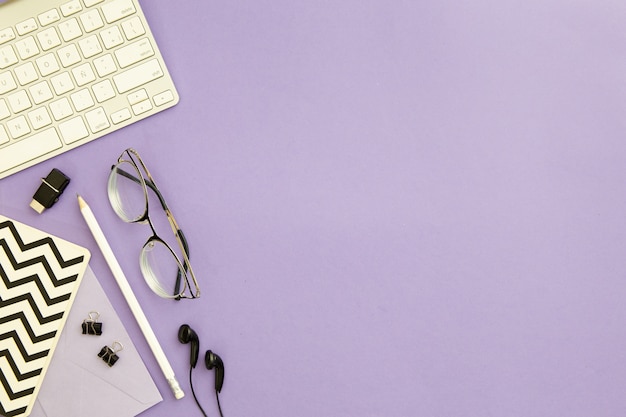Arranjo de local de trabalho vista superior em fundo roxo, com espaço de cópia Foto gratuita