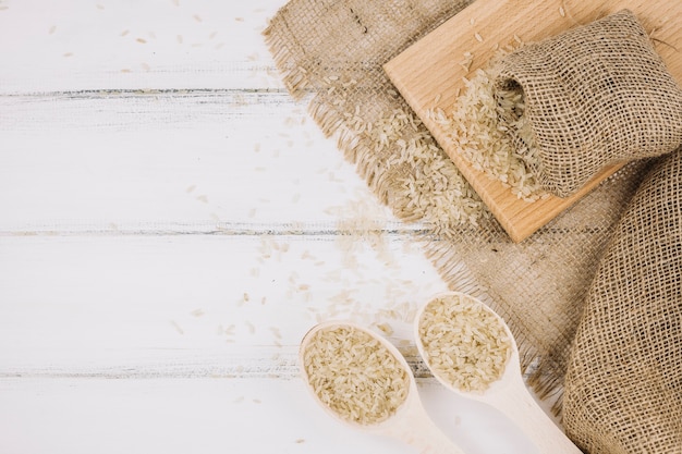 Arroz em colheres e saco Foto gratuita
