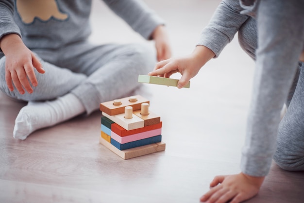 As crianças brincam com um designer de brinquedos no chão do quarto das crianças. Foto Premium