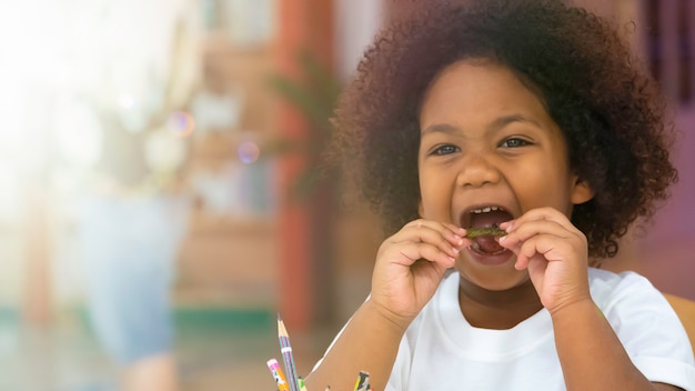 As crianças da criança que sorriem apreciam comer o petisco com felicidade. Foto Premium