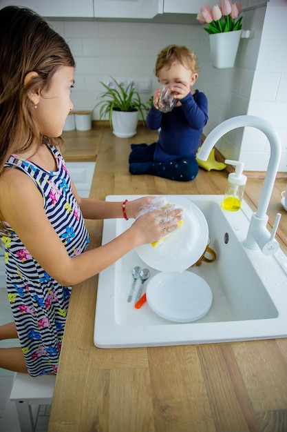 As Crian As Lavam Pratos Na Cozinha Foco Seletivo Crian A Foto Premium