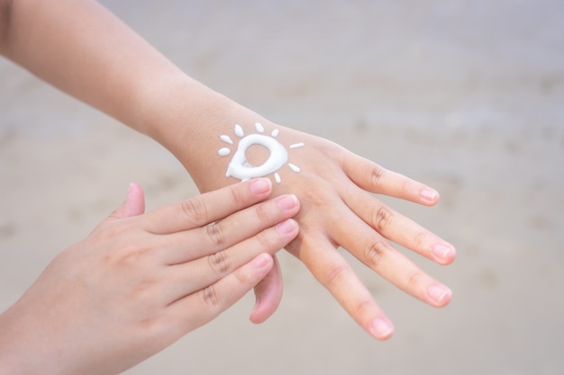 As mulheres asiáticas aplicam protetor solar nas mãos e nos braços. para  proteger a pele da luz solar, | Foto Premium