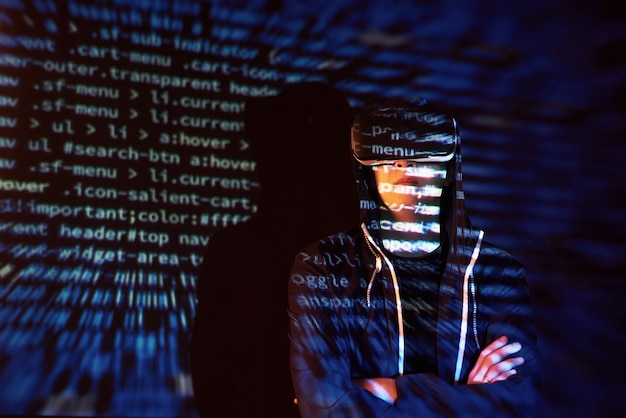 Ataque cibernético com hacker encapuzado irreconhecível usando realidade virtual, efeito de falha digital Foto gratuita