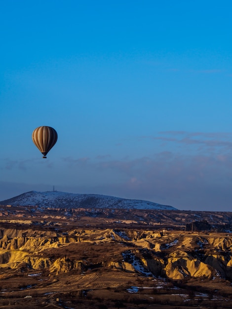 Balões de ar quente voando sobre a montanha na capadócia goreme national park turquia Foto Premium