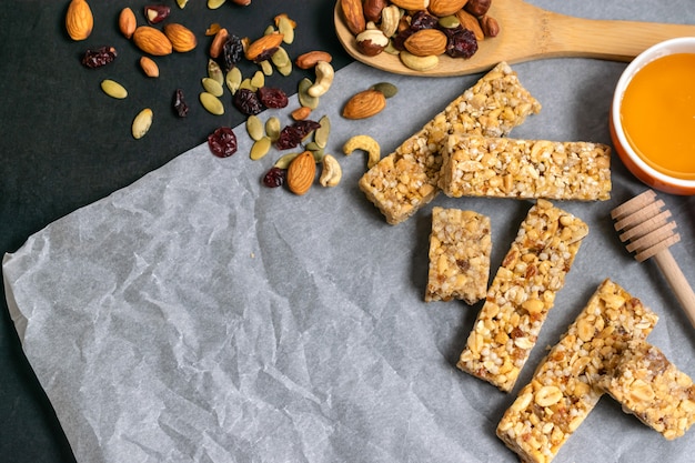 Barras de cereais caseiras saudáveis e granola com nozes, frutas secas e mel Foto Premium