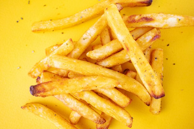 Batatas assadas com ervas aromáticas em um fundo amarelo. Foto Premium