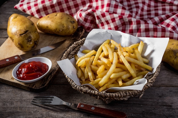 Batatas fritas na mesa de madeira Foto Premium