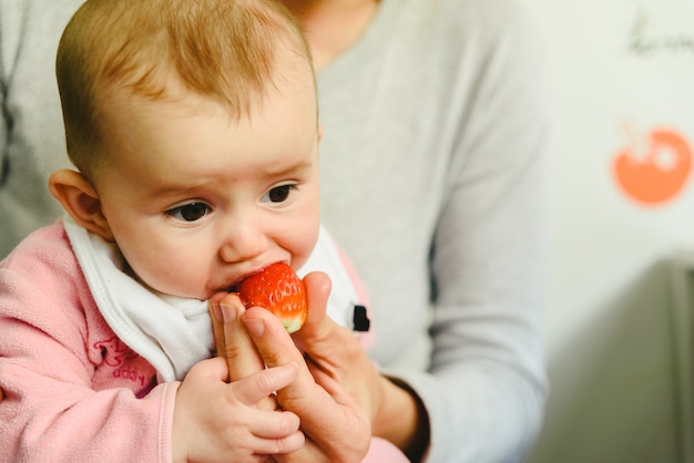 Bebé de 4 meses a começar a experimentar os primeiros alimentos utilizando a técnica de baby led weaning (blw) Foto Premium