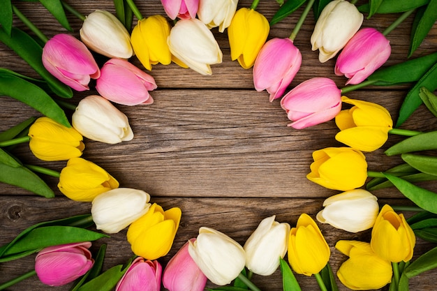 Bela composição com tulipas coloridas com espaço de cópia na madeira Foto gratuita