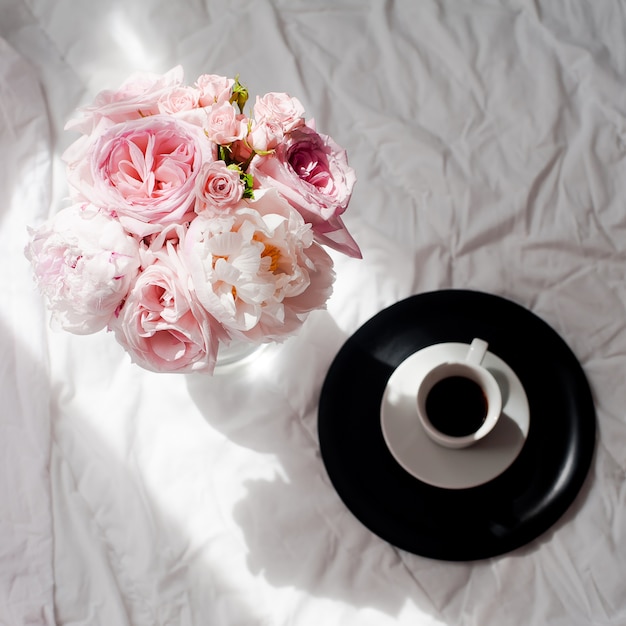 Beleza apartamento leigos com café e buquê de rosas de flores e pions Foto Premium