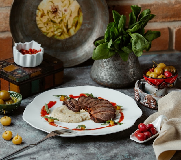Bife finamente cortado, servido com guarnição de arroz e molho de tomate Foto gratuita