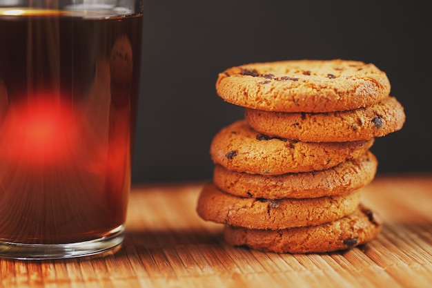 Biscoitos de aveia com pedaços de chocolate e uma caneca de chá preto aromático Foto Premium