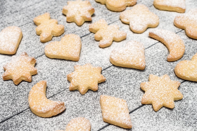 Biscoitos em forma de natal com açúcar em pó na mesa de madeira Foto Premium
