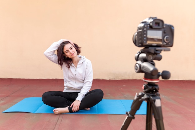 Blogueira morena gravando a rotina de yoga Foto gratuita