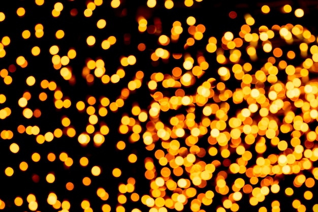 Bokeh abstrato unfocused do ouro no fundo preto. desfocado e desfocado muitas luzes redondas Foto Premium