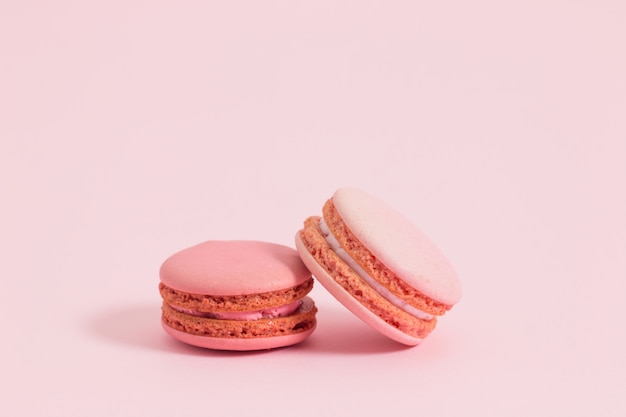 Bolinhos de amêndoa ou macaron francês doce e colorido no fundo cor-de-rosa, sobremesa. Foto Premium