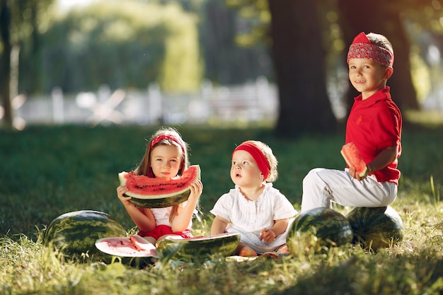 Bonitos crianças com melancias em um parque Foto gratuita