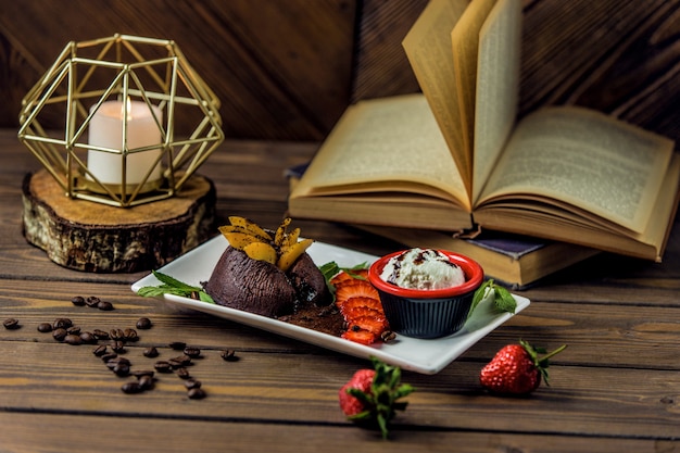 Brownies de chocolate servidos com molho cremoso e combinação de frutas Foto gratuita