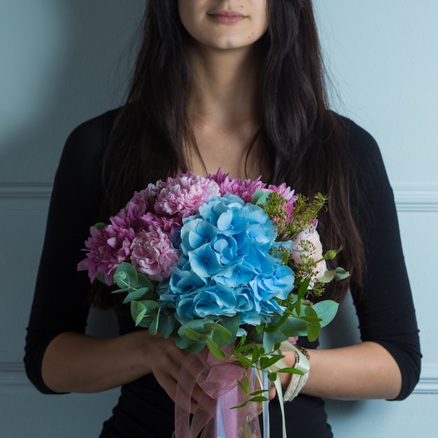 Buquê de flores tonned rosa e azul nas mãos de uma mulher Foto gratuita