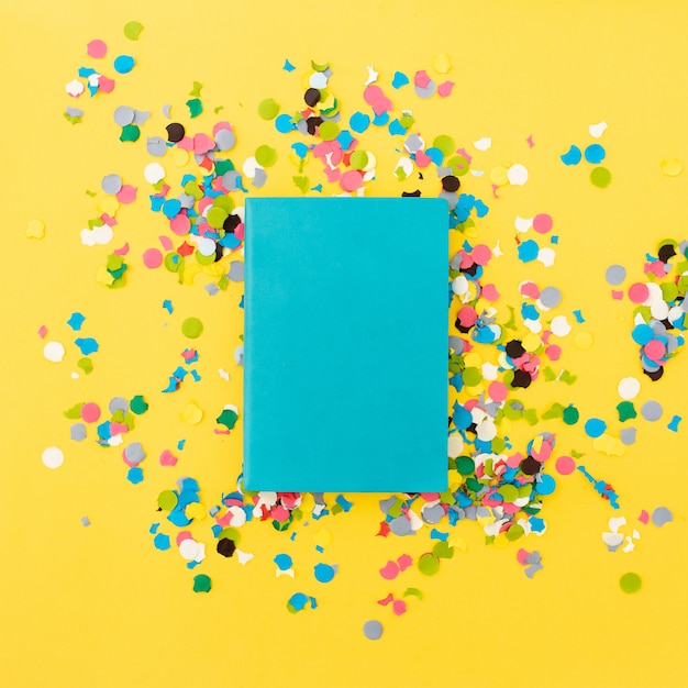 Caderno bonito para mock up em fundo amarelo com confete em torno Foto gratuita