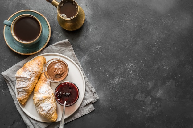 Café da manhã francês do conceito com café preto e croissant. vista do topo. copie o espaço para texto. Foto Premium