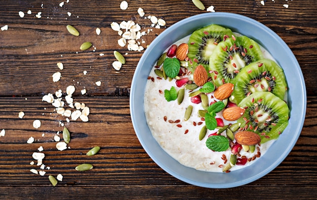 Café da manhã saudável. aveia com kiwi, romã, sementes de linho e nozes. menu de desintoxicação. vi superior Foto Premium