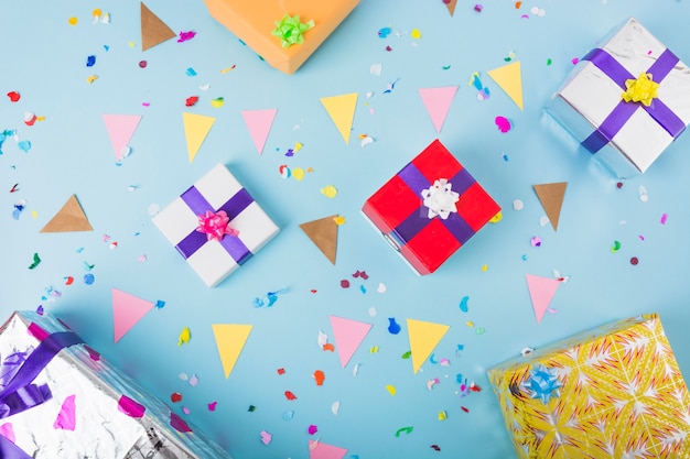 Caixas de presente decorativo com bandeira de estamenha e confetes sobre o fundo azul Foto gratuita