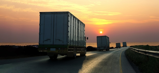 Caminhão na estrada rodovia com recipiente, logística industrial com céu do nascer do sol Foto Premium