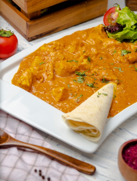 Caril indiano com peito de frango e molho de tomate servido com lavash. Foto gratuita