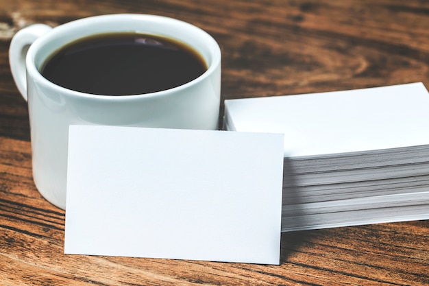 Download Cartões de visita em branco e xícara de café na mesa de madeira. o modelo de marca estacionária ...