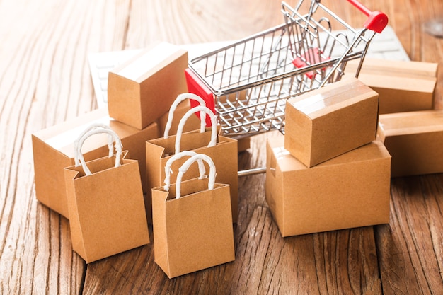 Carton em um carrinho de compras em um teclado de laptop. compras on-line é uma forma de comércio eletrônico que permite aos consumidores comprar diretamente mercadorias de um vendedor pela internet Foto Premium