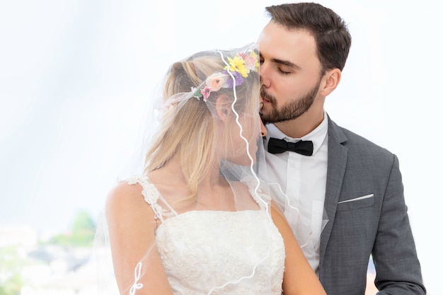 Casal de noivos caucasiano beijo e abraço no estúdio de casamento. Foto Premium