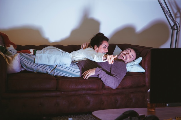 Casal Deitado No Sofá E Assistindo A Um Filme Baixar Fotos Gratuitas