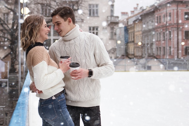 Casal do jovem casal apaixonado data na pista neva bebendo cacau Foto Premium