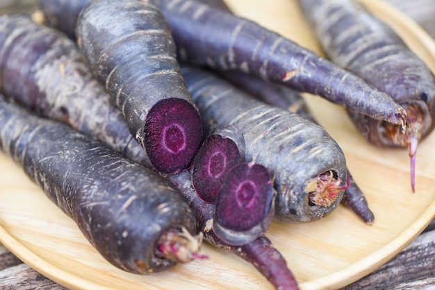 Cenoura Roxa Na Placa De Madeira Cenoura Fresca Para Cozinhar Comida Vegetariana Na Mesa De Madeira Foto Premium