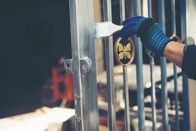 Cerca de pintura de trabalhador de construção em casa Foto gratuita