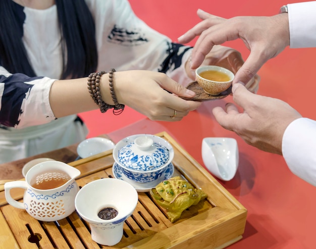 Cerimônia do chá chinês. a garota despeja o chá da chaleira no ...