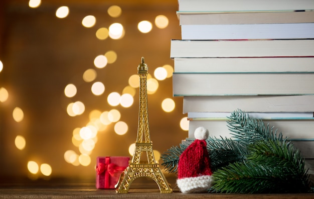 Chapéu de papai noel de natal com a torre eiffel e pilha de livros Foto Premium