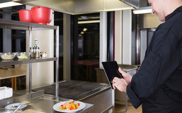 Chef com um tablet Foto gratuita