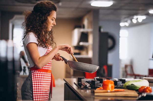 Chef De Mulher Cozinhar Legumes Na Panela Foto Grátis