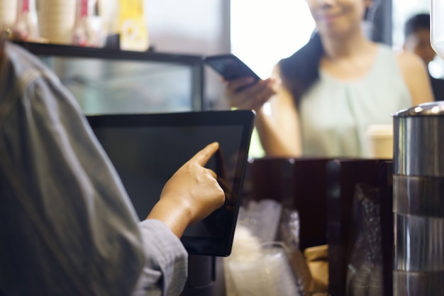 Cliente encomendar comida e bebida com o uso de seu smartphone e alta tecnologia nfs para pagar um barista Foto Premium