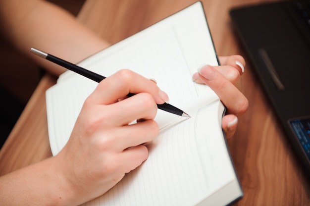 Close De Uma Mão Feminina Escrevendo Em Um Caderno Em Branco Com Uma Caneta Foto Premium 2528