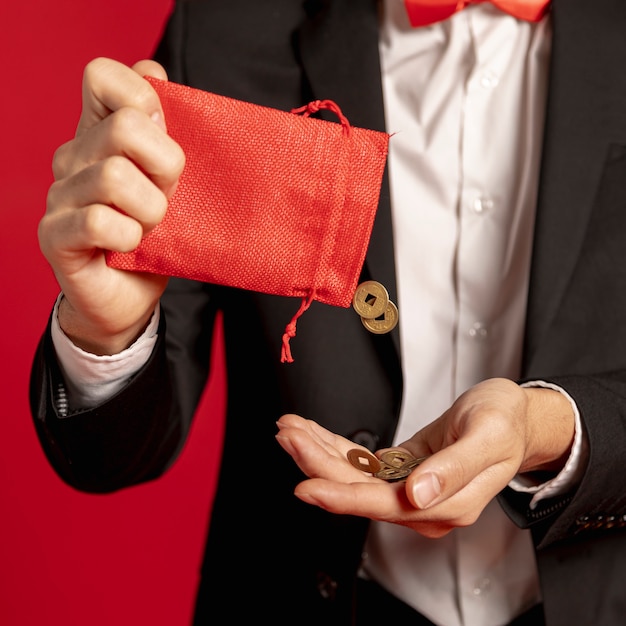 Close-up da bolsa vermelha com moedas de ouro pelo ano novo chinês Foto gratuita